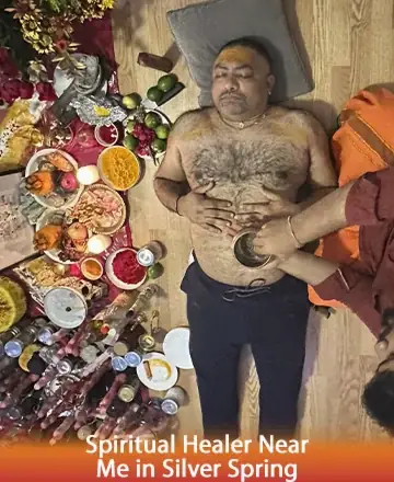 In a tranquil setting adorned with vibrant colors and sacred offerings, a serene individual receives a calming spiritual ritual. Gentle hands provide healing, embodying trust and wisdom. This peaceful moment brings warmth to the soul. Spiritual healer near me in Silver Spring.