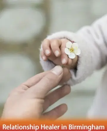 A gentle exchange of trust and innocence unfolds as a child's tiny hand offers a delicate flower. This tender moment speaks of connection and nurturing care, evoking a serene sense of harmony and love. Relationship healer in Birmingham.