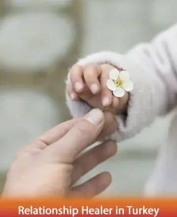 In a gentle moment of connection, a small hand offers a delicate blossom, symbolizing trust and the tender bonds we share. This serene image captures the essence of care and warmth, inviting a sense of peace within. Relationship healer in Turkey.